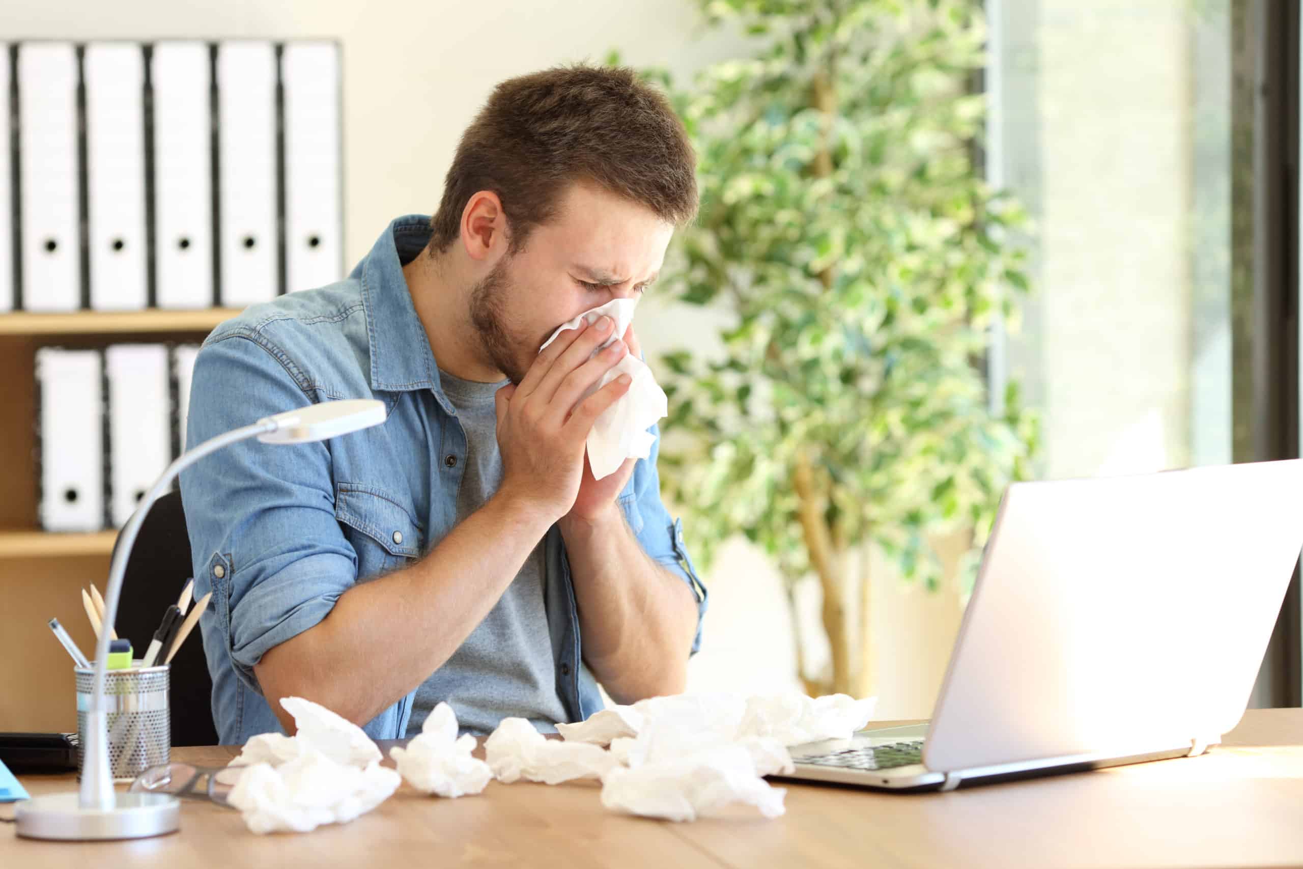 man sneezing into tissue due to poor indoor air quality